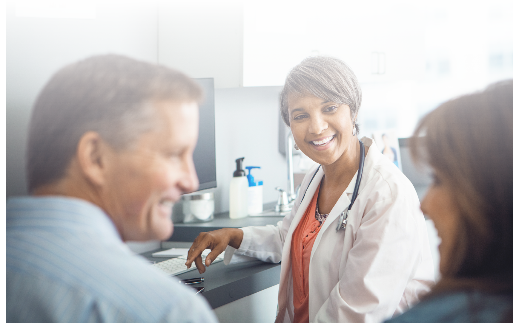 Female doctor talking with couple in office